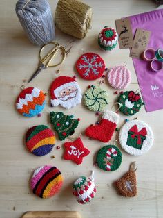 knitted christmas ornaments are laid out on a table with knitting needles and other crafting supplies