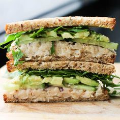 a cut in half sandwich with chicken, lettuce and cucumber on it