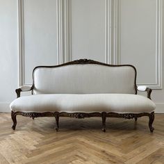 a white couch sitting on top of a wooden floor