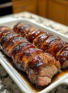 meat wrapped in sauce on a white plate