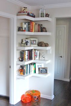 there is a bookshelf in the room with many books on it and two pumpkins