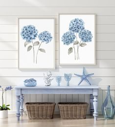 two blue flowers are on the wall next to a table with baskets and vases