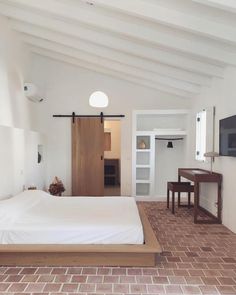 a bedroom with brick flooring and white walls