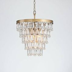 a chandelier hanging from the ceiling with clear glass beads and a brass frame