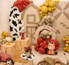 a table topped with lots of balloons and farm animals