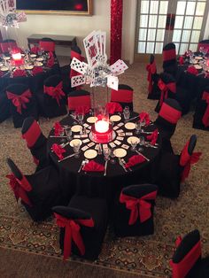 a room filled with black and red chairs covered in table cloths next to a fireplace