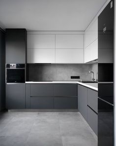 an empty kitchen with gray and white cabinets