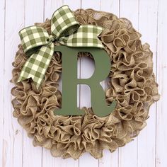 a wreath with the letter r on it and a green bow hanging from the front