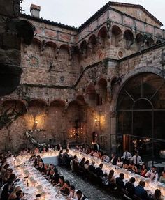 a large group of people sitting at tables in an old building