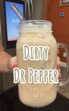 a person is holding a drink with the words dirty dr pepper on it in front of them