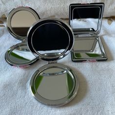 four compact mirrors sitting on top of a bed