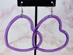 "♥ Large Purple Heart Plastic Hoop Earrings ♥ These earrings feature translucent purple plastic hearts, affixed to surgical steel alloy ear wires. Silicone back fasteners are included. If you are interested in these earrings, but require a different type of ear wire for allergy concerns, feel free to contact me and I will try to accommodate your request! They measure 9cm (3.55\") in length, and 6.5cm (2.55\") at their widest point. All findings are brand new and all jewelry is created in a clean work space. As an additional health and safety precaution, all earrings are disinfected in bio-septic earring cleanser immediately prior to packaging in an air tight package. If you have any questions about this product, feel free to message me!" Purple Flame, Heart Hoop Earrings, 90s Nostalgia, Purple Heart, Ear Wire, Ear Wires, Jewelry Earrings Dangle, Etsy Earrings, Dangle Drop Earrings