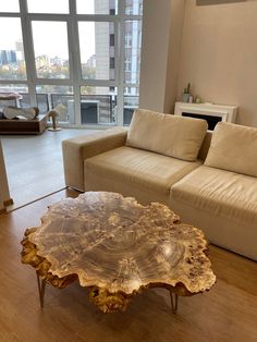 a living room with couches and a table in front of a large glass window