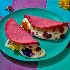 two pieces of cake on a blue plate with pink and yellow flowers in the middle