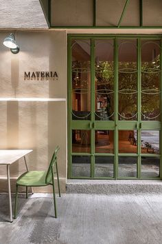 a green chair and table in front of a building