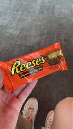 a person holding a reese's bar in their hand