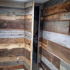 an open door in a wooden room with wood planks on the walls and floor