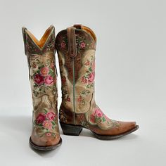 An ode to our Signature style, Bonnie, the Bridgette brings a metallic and colorful twist. Cross-stitched floral embroidery in hues of blush on the gold metallic backdrop and green piping details on a classic cowgirl boot silhouette. Pair it with jeans or dresses; the boot will talk for you. Height: 13" Cowgirl Boots Colorful, Fall Rodeo Embroidered Boots, Fancy Shoes For Women, Vintage Embroidered Fall Boots, Spring Embroidered Boots For Rodeo, Cowgirl Boots Aesthetic, Metallic Backdrop, Womens Cowgirl Boots Floral, Floral Cowboy Boots