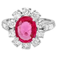 a pink and white ring with diamonds around it