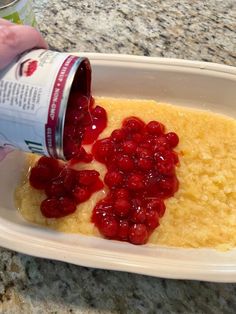 someone is pouring something into a dish with cranberries on it