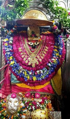 an elaborately decorated statue with flowers on it's chest and head in the center