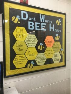 a bulletin board on the wall in a classroom with bees and honeycombs attached to it