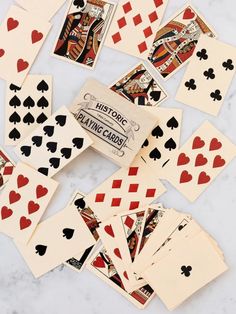 playing cards are laid out on a marble counter top, with the words historic playing cards in red and black