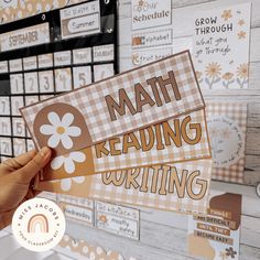 a person holding up a card with the words math reading writing on it in front of a wall