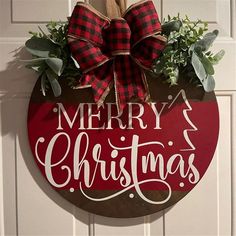 a merry christmas sign hanging on the front door with greenery and burlocks