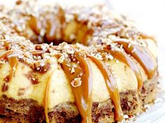 a bundt cake covered in caramel drizzle and nuts on a plate