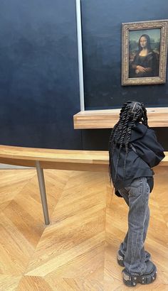 a person with a backpack standing in front of a painting