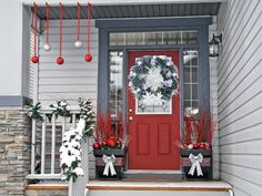 a red front door decorated with christmas decorations