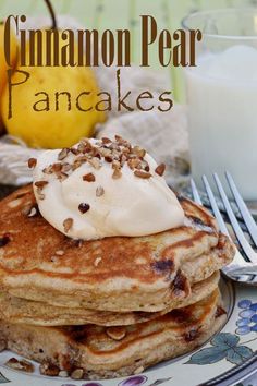 a stack of pancakes topped with whipped cream and pecans