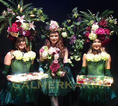 three women dressed in green dresses and flower crowns are posing for the camera with flowers on their heads