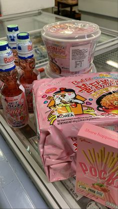 an assortment of food items are on display in a grocery store case, including rice noodles and yogurt