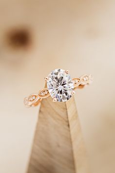 a close up of a diamond ring on top of a wooden stand