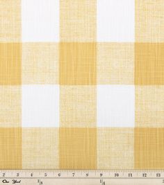 a yellow and white checkered fabric with a ruler in front of the plaid pattern