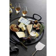 an assortment of cheese on a black plate