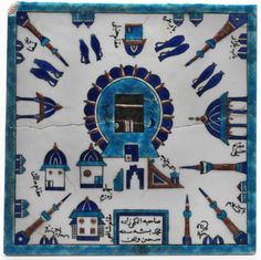 an artistic tile with blue and white designs on it's sides, including buildings