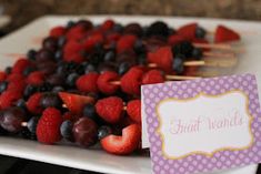 fruit skewers are arranged on a white plate