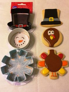 decorated cookies and cookie cutters are sitting on a table