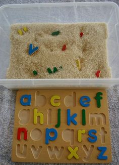 a plastic tray with letters and numbers in it next to a plastic container filled with rice