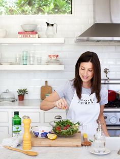 a woman is preparing a salad in the kitchen