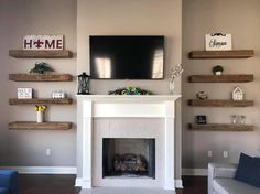 a living room with a fire place and shelves on the wall above it, along with a flat screen tv