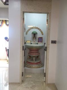 an open door leading into a room with white walls and marble flooring on the ground