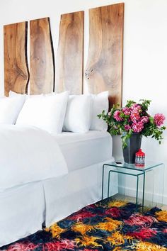 a bedroom with three wooden headboards on the wall and a flower vase in front of it