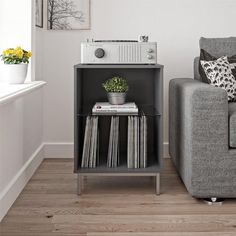 a living room with a couch, table and radio on the shelf next to it