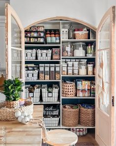 an open pantry filled with lots of food and storage space next to a wooden table