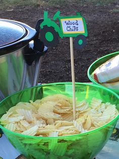 a green bowl filled with pasta sitting on top of a table next to an ice bucket