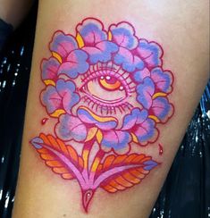 an artistically designed tattoo on the leg of a woman's thigh, with pink and purple flowers